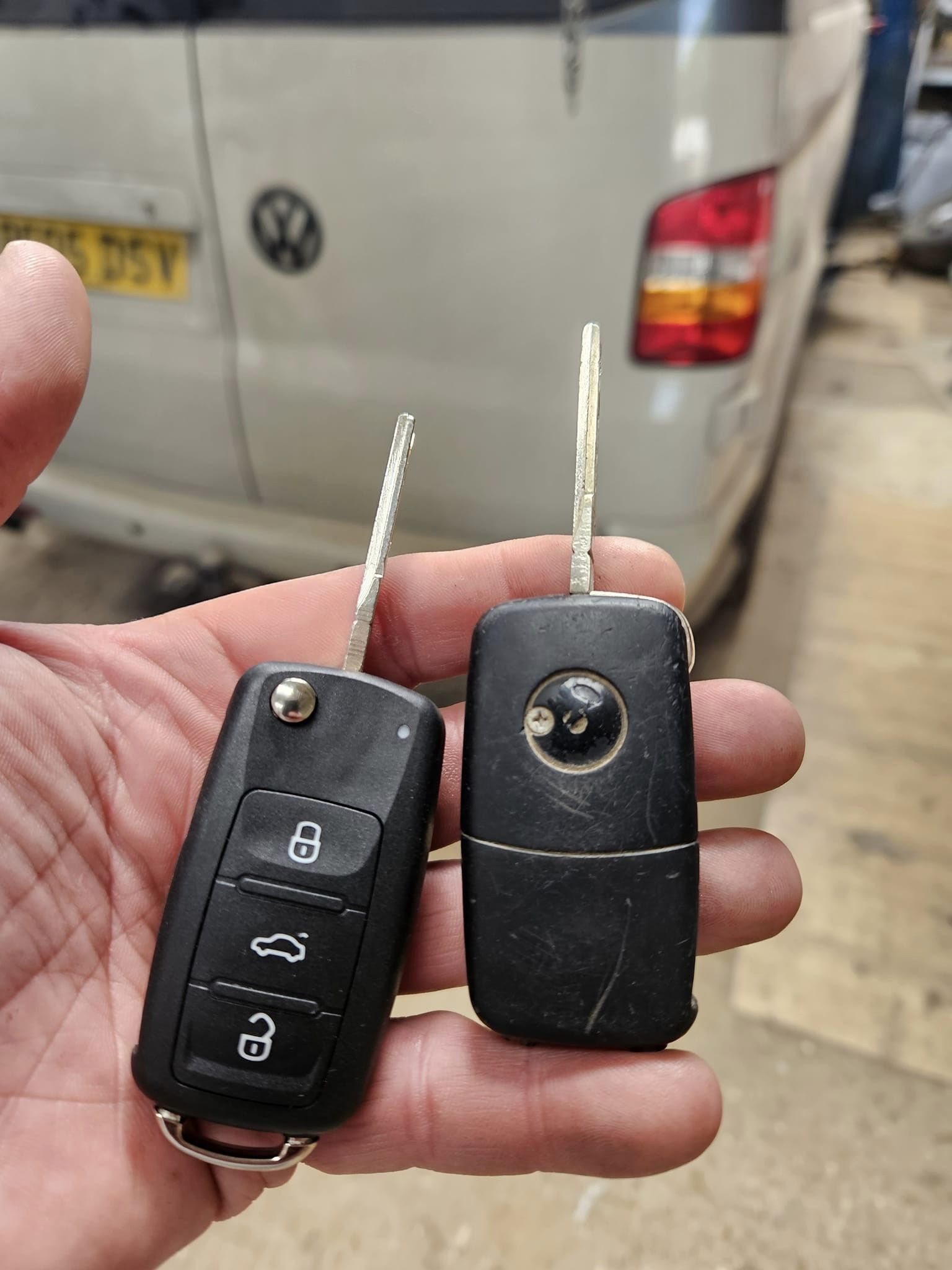 Man holding a new and old key fob for vw van